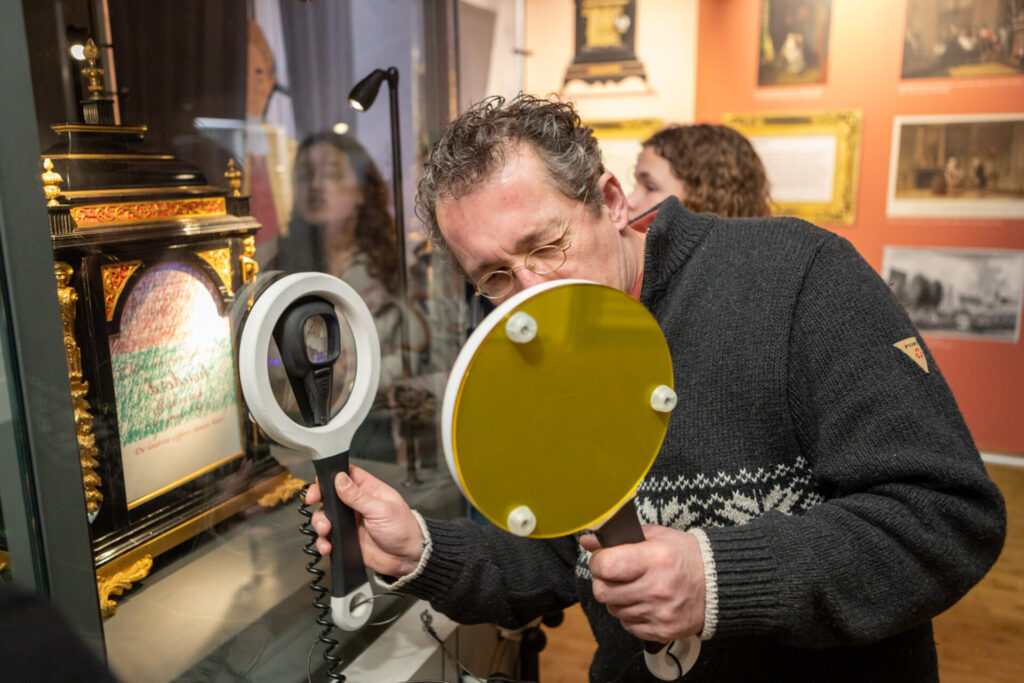 Vader in de Escape Game met een vergrootglas