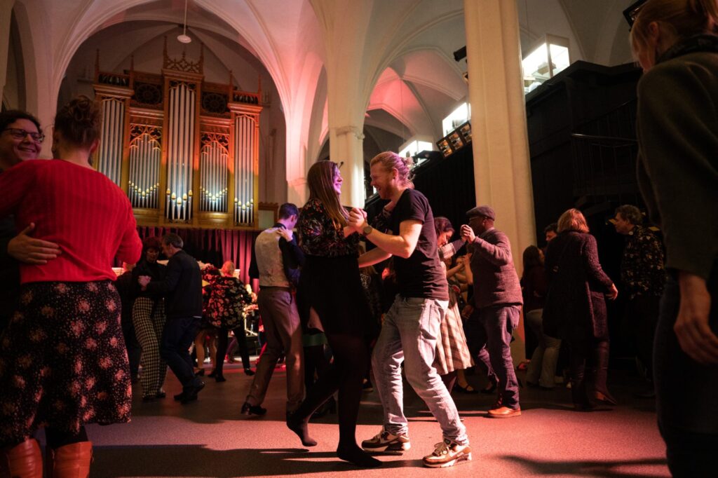 Twee mensen dansen in het Middenschip tijdens de Let's Dance avond van de roaring twenties