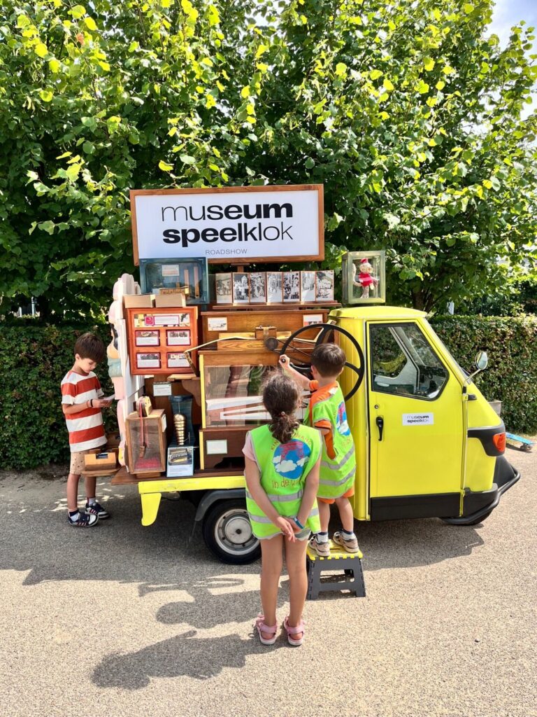 Een jongen draait aan het orgeltje van de Speelklok Roadshow