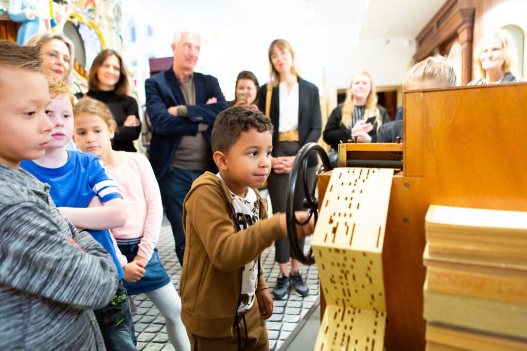 Kind draait aan een klein orgeltje