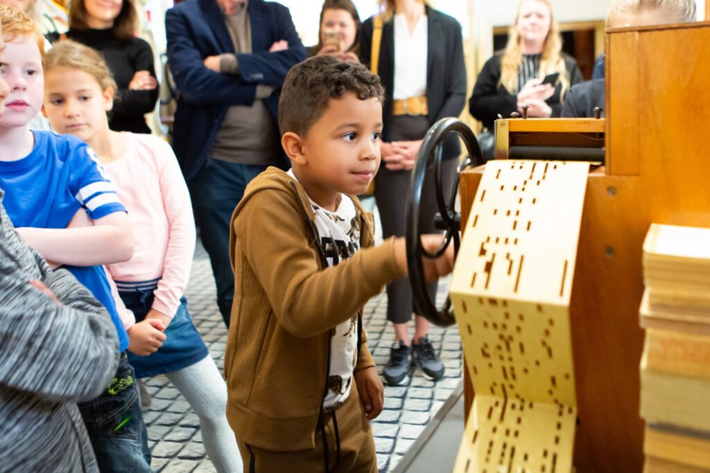 Jongen draait aan een orgeltje