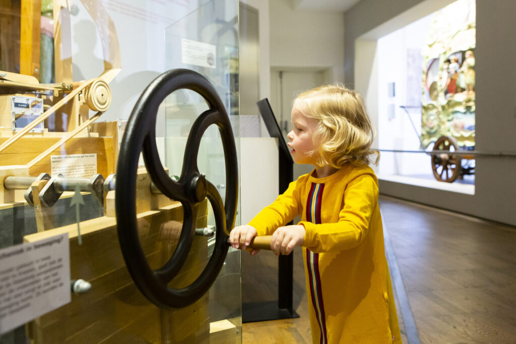 Klein meisje draait aan een orgelwiel