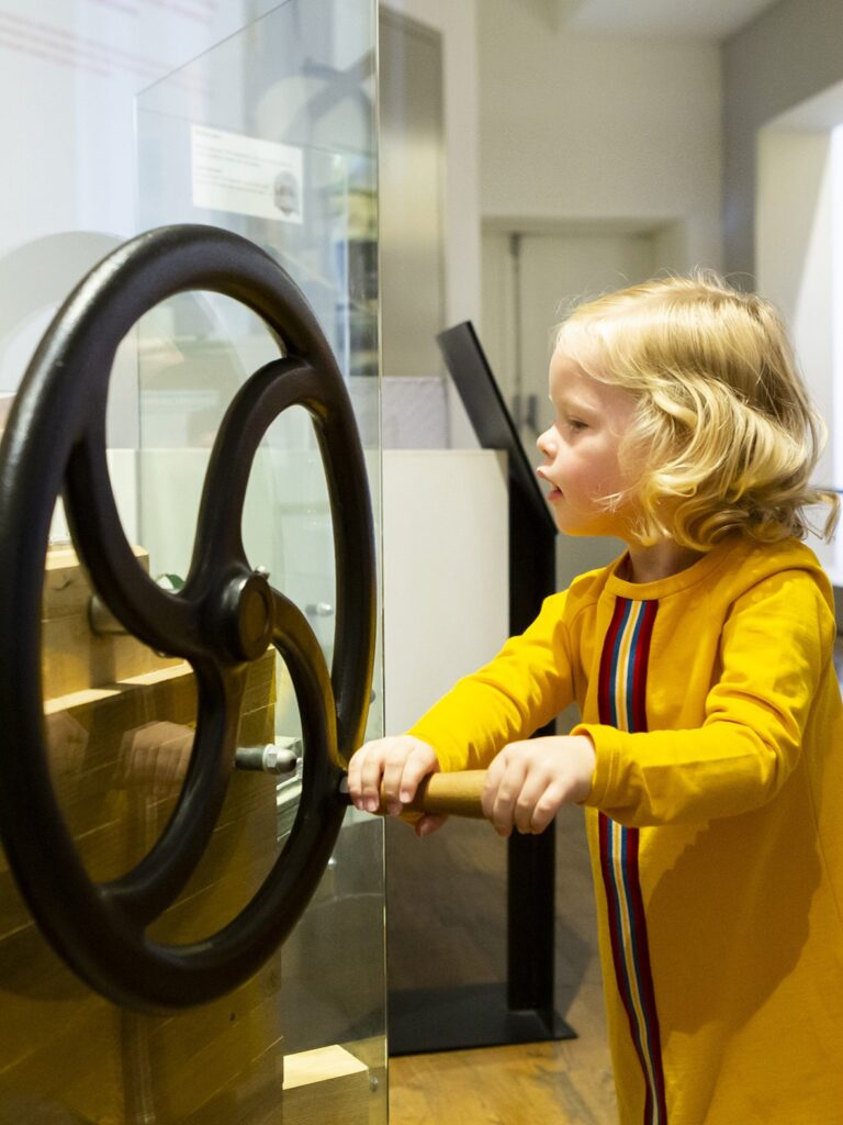 Klein meisje draait aan een orgelwiel